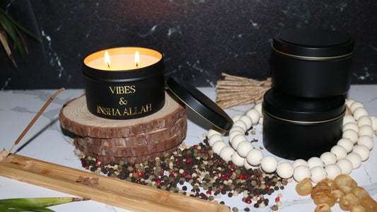 Hand poured black candle tin with a gold metal logo label, featuring multiple organic wicks, burning with a warm glow. The candle is made with natural coconut and soy wax and non toxic fragrance oils. Decorative candle for aesthetic appeal